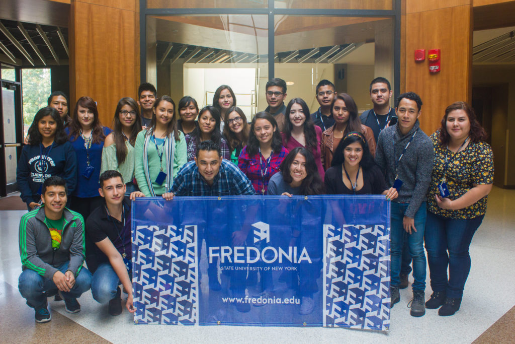 Proyecta students pose with a Fredonia flag. (Corey Maher/Photo Editor)
